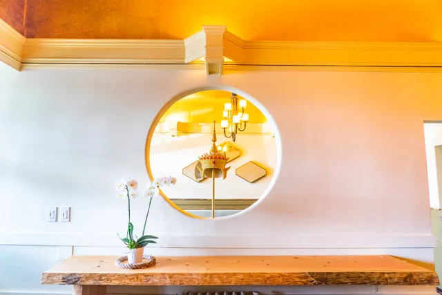 Gold ceiling and round mirror in the dining room at Nohra Thai Kitchen