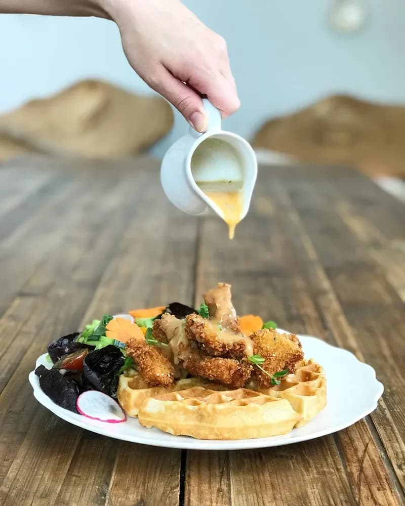 Sauce poured over Liv’s crispy chicken and waffle