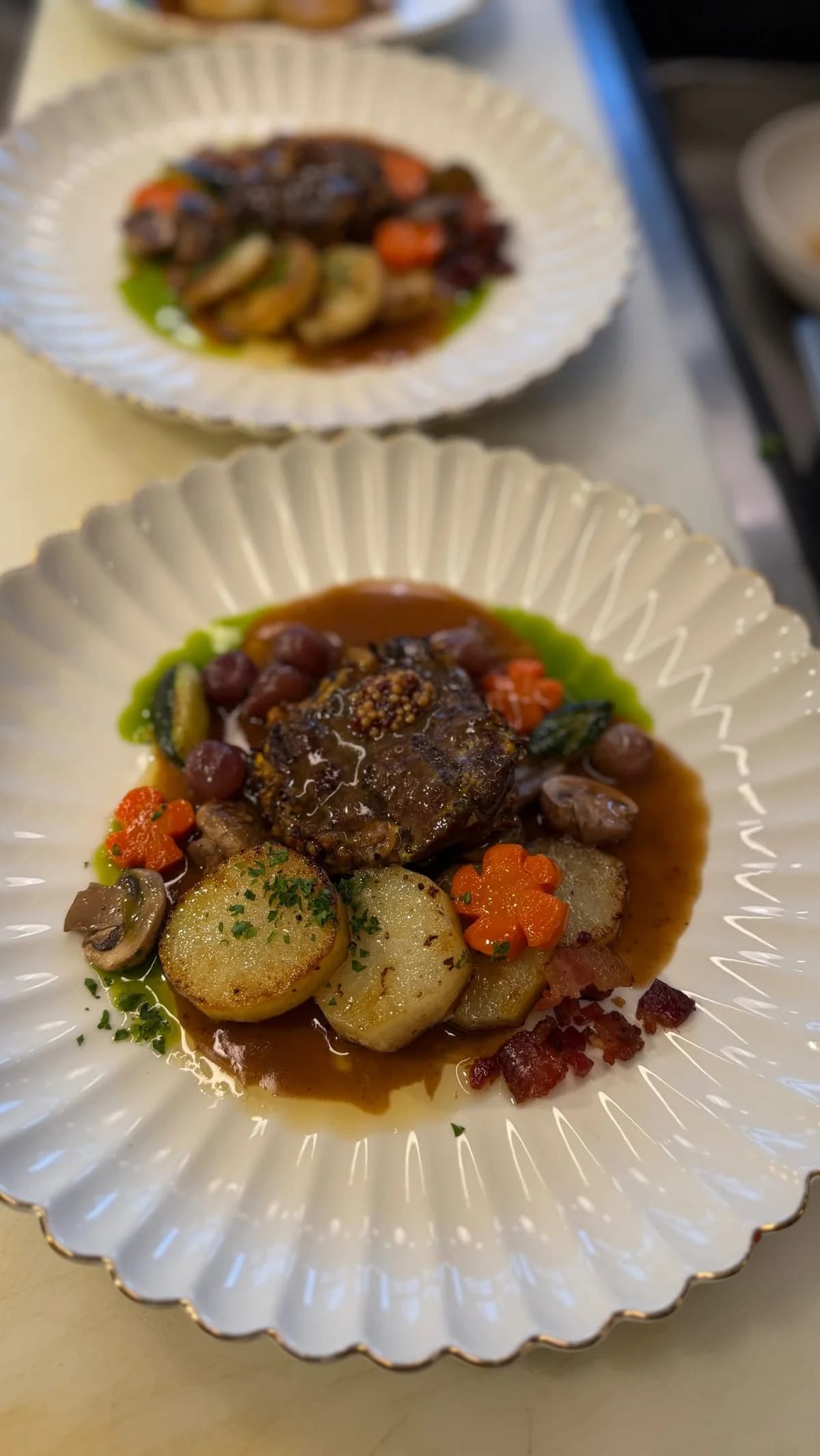 A plated beef dinner with potatoes and vegetables at Liv