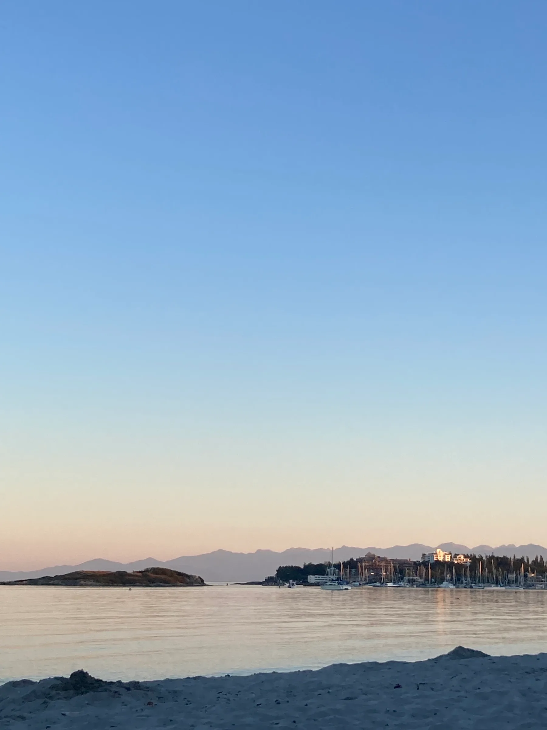 The water and sandy shoreline at Willows Beach glow in the evening light